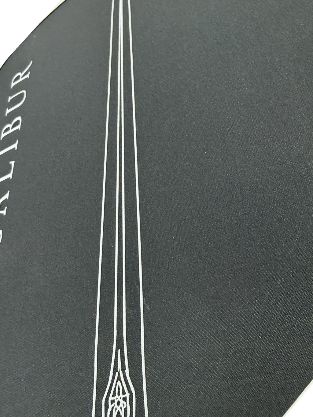 Close-up of the Excalibur paddle face texture and sword artwork