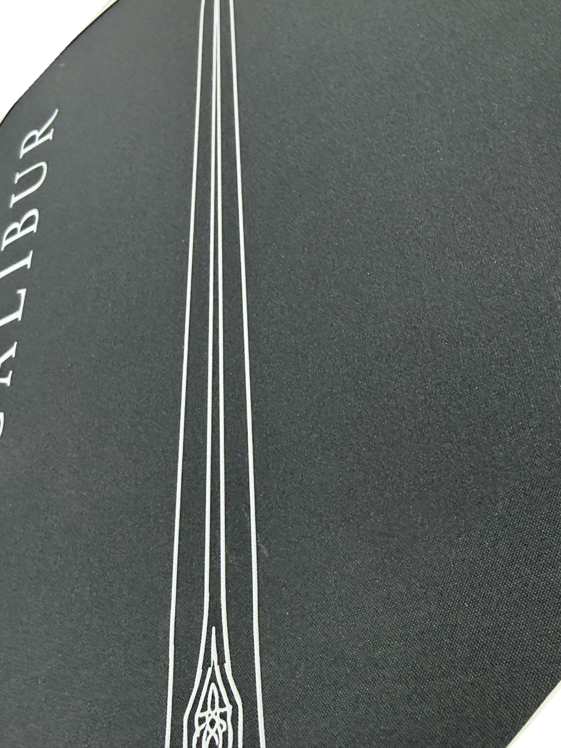 Close-up of the Excalibur paddle face texture and sword artwork
